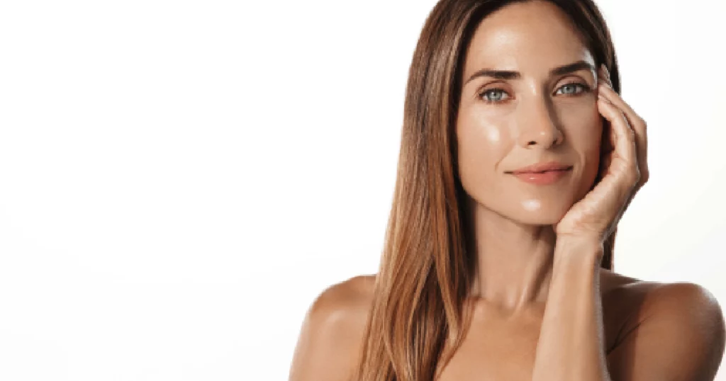 Woman with glowing skin after DiamondGlow, touching her face in Sparta, NJ.